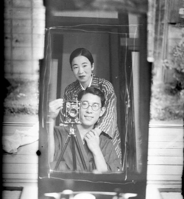 Original faded photo of Japanese couple with camera